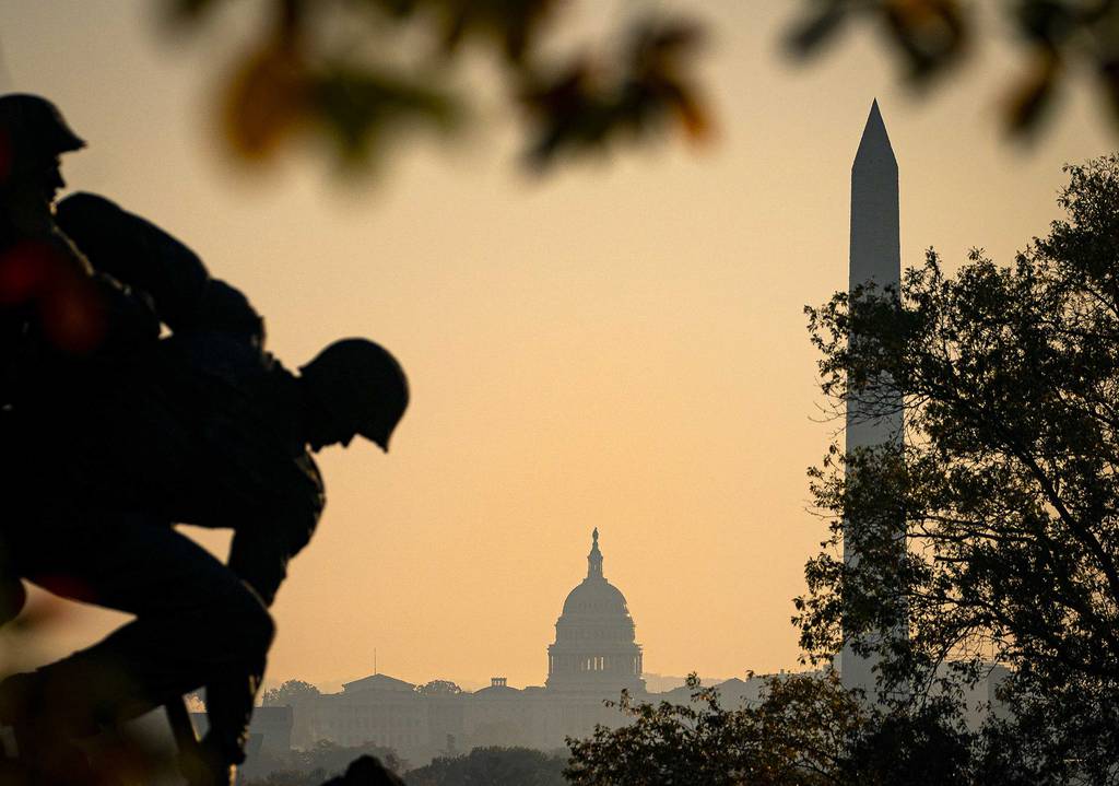 The U.S. Marine Corp's Iwo Jima Memorial can be seen as the morning sun begins to rise behind the U.S. Capitol and Washington Monument on Nov. 7, 2020, in Arlington, Va.