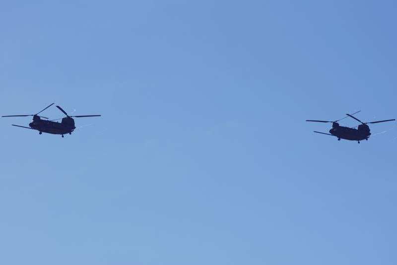 Two Chinook helicopters fly over the San Diego Bay on Feb. 15, 2024, during the final day of the West naval conference.