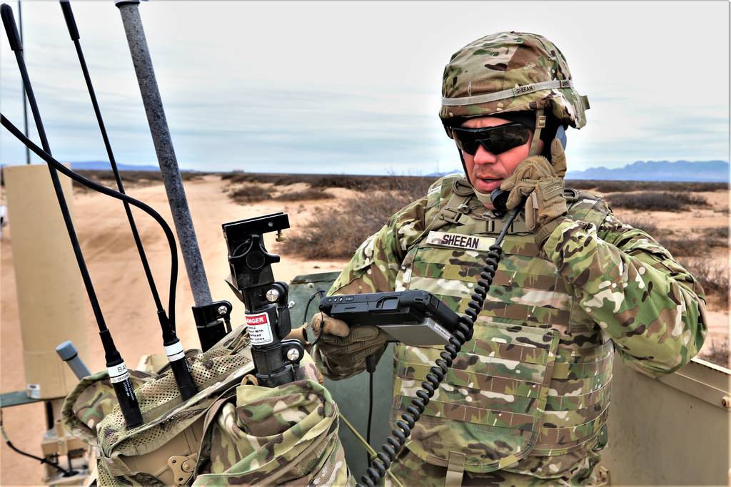 Staff Sgt. Micah Sheean, an electronic warfare specialist, communicates from the high mobility multipurpose wheeled vehicle with mobile personnel.