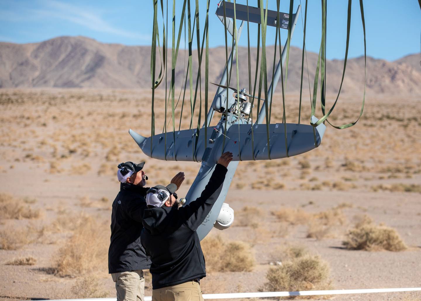 Military contractors take a drone down from a recovery net on Nov. 4, 2022, at Fort Irwin, California.