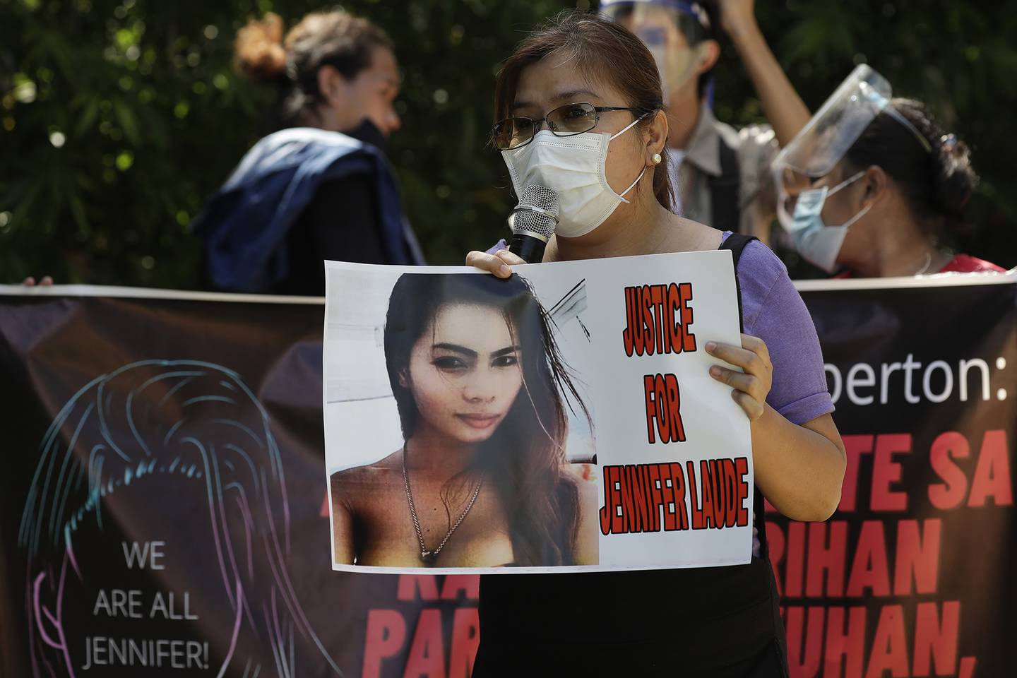 A protester holds a slogan with a photo of the killed transgender Filipino woman Jennifer Laude during a rally in Quezon city, Philippines, Friday, Sept. 11, 2020.