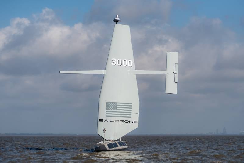 A Saildrone Surveyor unmanned surface vessel is seen moving through the water.