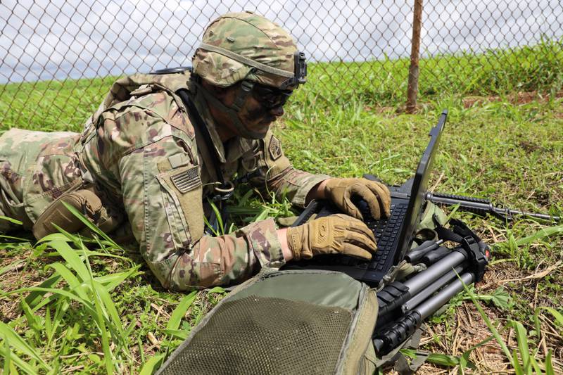 U.S. Army Sgt. James Hyman collects information from two sensors — on an unmanned aerial system and a robotic dog — in order to conduct cyber operations during an operational readiness assessment in March 2023.