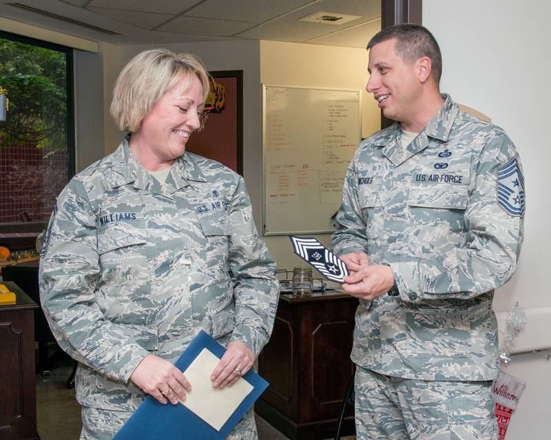 Air Force Chief Master Sgt. Steve Nichols, 60th Air Mobility Wing command chief, presents Senior Master Sgt. Lisa Williams of the 60th Medical Group with her stripe upon her selection to chief master sergeant at Travis Air Force Base, Calif., Dec. 7, 2016. (Louis Briscese/Air Force)