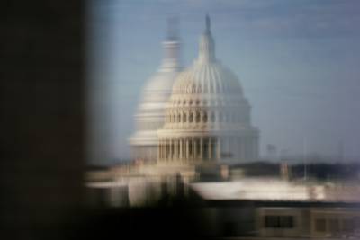 The Capitol is seen reflected on a window of the Keck Center, a National Academies building, in Washington, D.C., on Feb. 19, 2023.