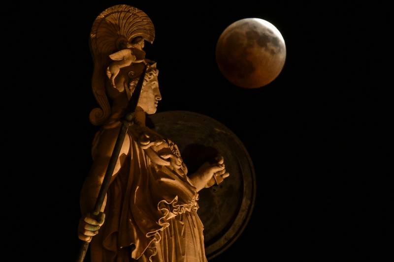 A statue depicting ancient Greek goddess Athena in central Athens is seen during a "blood moon" eclipse in July 2018.