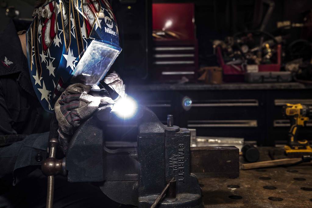 Hull Maintenance Technician 3rd Class Drew Knutson welds stainless steel and aluminum angles in the repair shop of the aircraft carrier USS Ronald Reagan (CVN 76) on July 8, 2020, in the South China Sea.