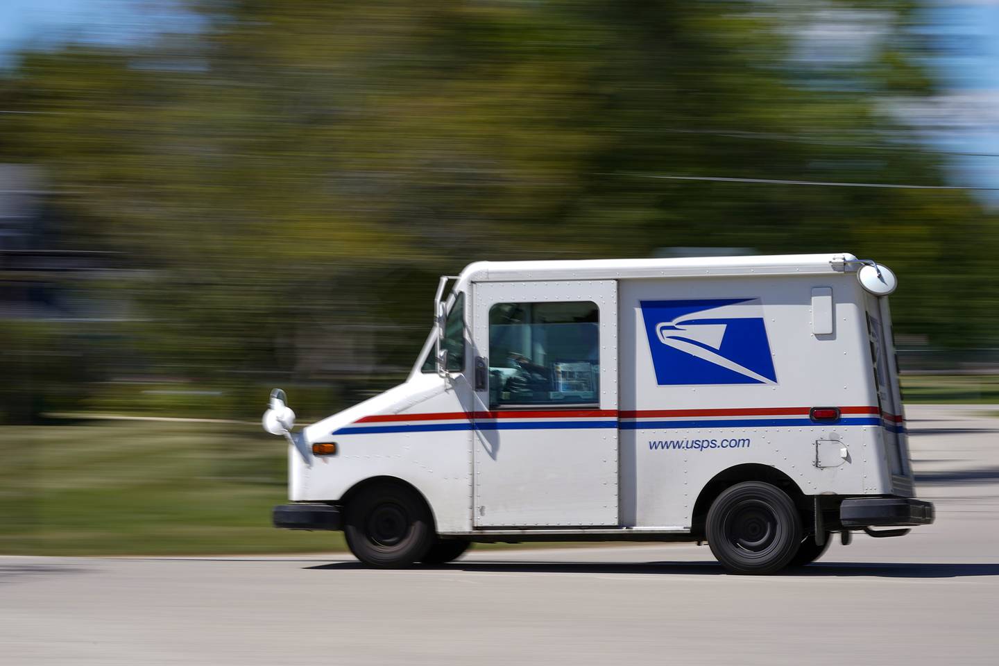 A mail truck moves down a street Aug. 18, 2020, in Fox Point, Wis.
