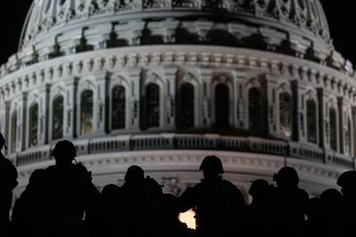 U.S. soldiers with the Virginia National Guard listen to a squad leader briefing after arriving near the Capitol in Washington on, Jan. 13, 2021.