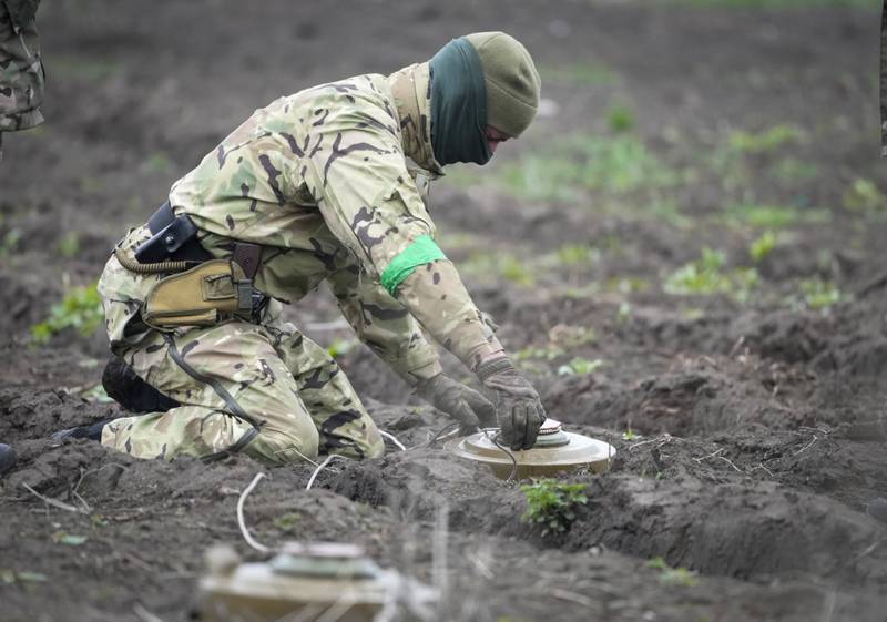 An interior ministry sapper defuses a mine on a minefield after recent battles in Irpin close to Kyiv, Ukraine, on April 19, 2022.