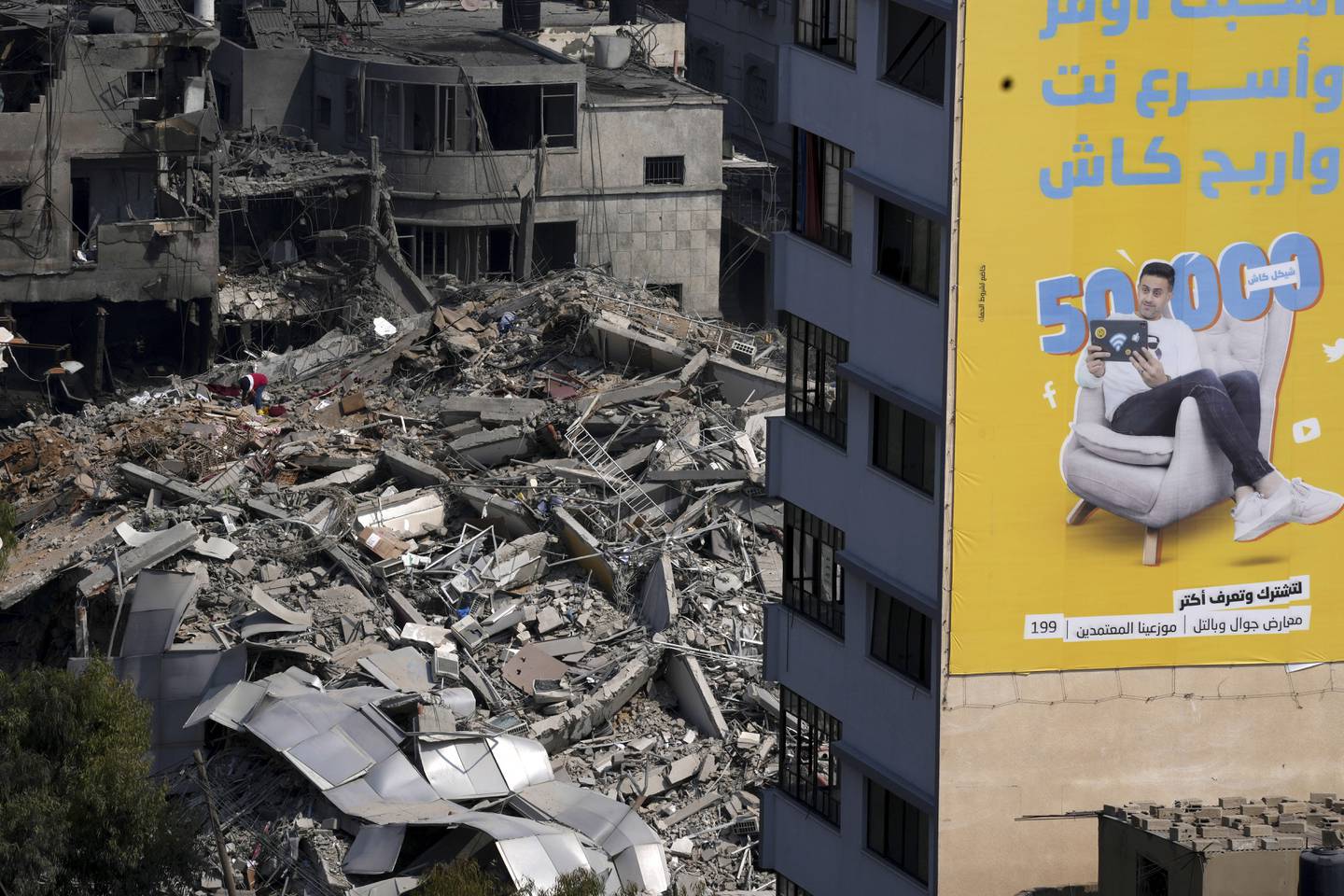 A Palestinian inspects the rubble of a high rise building destroyed by Israeli airstrikes in Gaza City early Sunday, Oct. 8, 2023.
